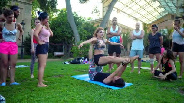 Una lección de grupo sobre acroyoga que tiene lugar en el parque — Vídeos de Stock