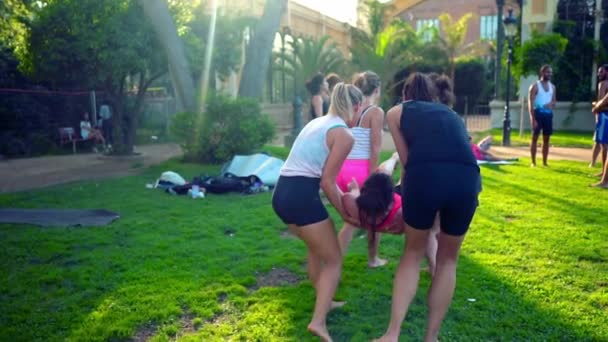 Een groepsles over acroyoga die plaatsvindt in Park — Stockvideo