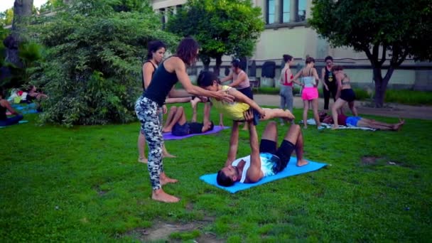 Lekcja grupowa na akroyoga, która odbywa się w parku — Wideo stockowe