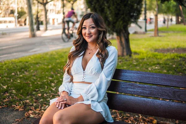 Hermosa chica asiática en vestido blanco sonriendo en el parque —  Fotos de Stock