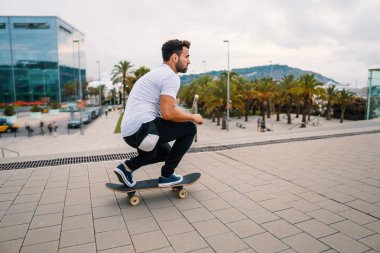 Kaykaycı modern şehir terasında bir kaykay sürmek.