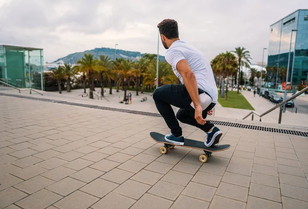 Skateboarder monta un monopatín en la moderna terraza de la ciudad . — Foto de Stock