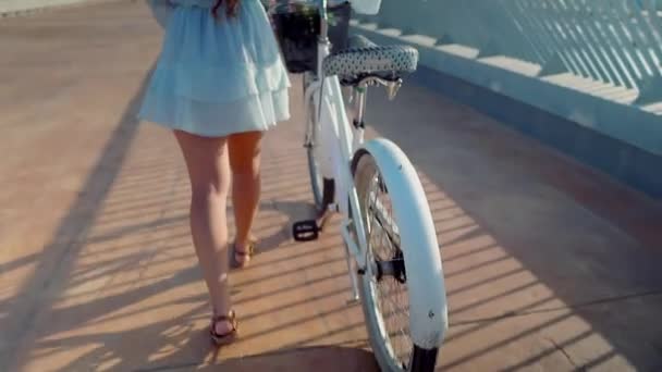 Modèle asiatique en robe bleue monte un vélo blanc sur la terrasse de la mer — Video