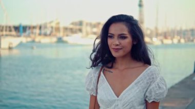 Deniz gezinti boyunca yürüyen beyaz elbiseli güzel kız