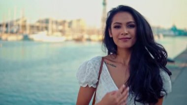 Deniz gezinti boyunca yürüyen beyaz elbiseli güzel kız