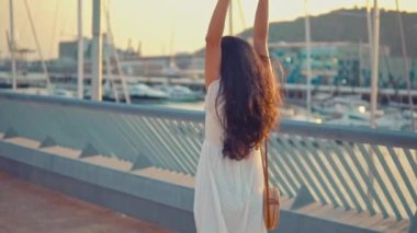 Deniz gezinti boyunca yürüyen beyaz elbiseli güzel kız