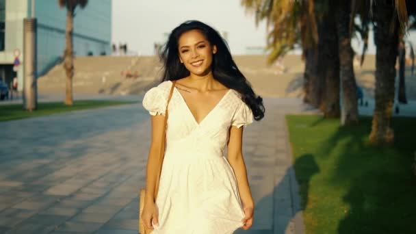Девушка в белом платье идет вдоль пальмовой террасы — стоковое видео