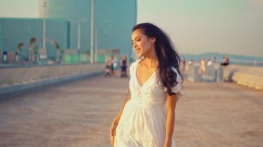 Deniz gezinti boyunca yürüyen beyaz elbiseli güzel kız