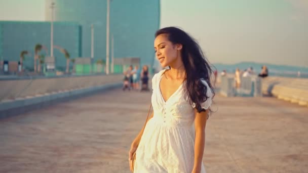美丽的女孩在白色礼服沿着海滨长廊散步 — 图库视频影像