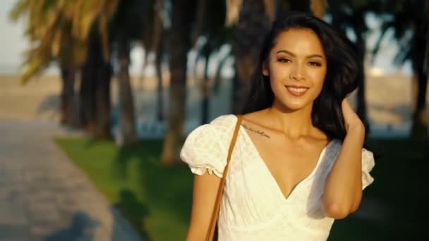 Chica en el vestido blanco caminando por la terraza de la palmera — Vídeo de stock