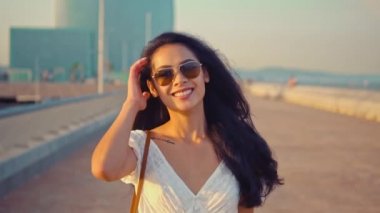 Deniz gezinti boyunca yürüyen beyaz elbiseli güzel kız