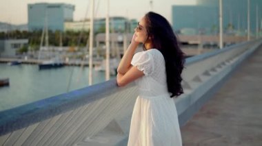 Deniz gezinti boyunca yürüyen beyaz elbiseli güzel kız