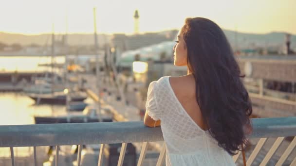Κορίτσι με το λευκό φόρεμα που στέκεται στη βεράντα περιπάτου θάλασσα — Αρχείο Βίντεο