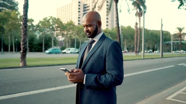 Индийский бизнесмен держит мобильный телефон в синем костюме — стоковое видео