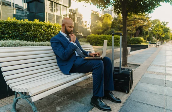 Hombre de negocios indio sosteniendo portátil portátil con traje azul cerca de la oficina —  Fotos de Stock