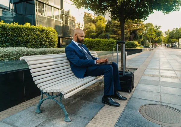 オフィスの近くに青いスーツを着てノートパソコンを持つインドのビジネスマン — ストック写真