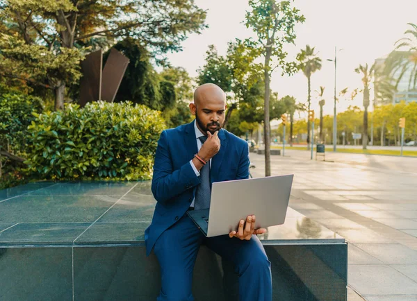 Hombre de negocios indio sosteniendo portátil portátil con traje azul cerca de la oficina —  Fotos de Stock