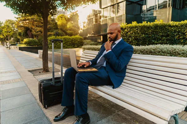 Hombre de negocios indio sosteniendo portátil portátil con traje azul cerca de la oficina —  Fotos de Stock