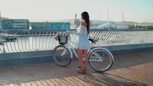 Азиатская модель в синем платье катается на белом велосипеде на морской террасе — стоковое видео