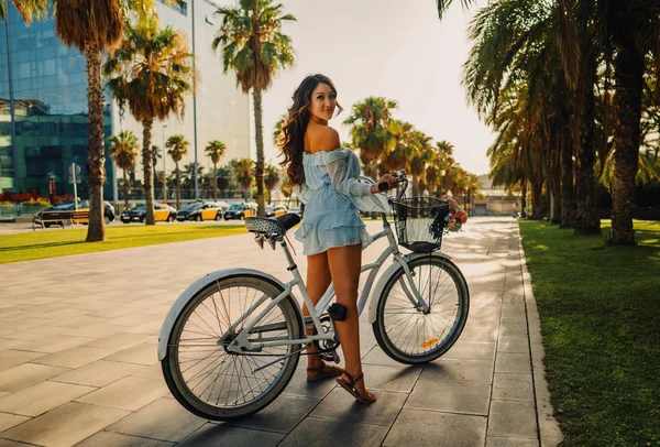 푸른 드레스를 입은 아시아 모델은 녹색 공원에서 흰색 자전거를 타고 — 스톡 사진
