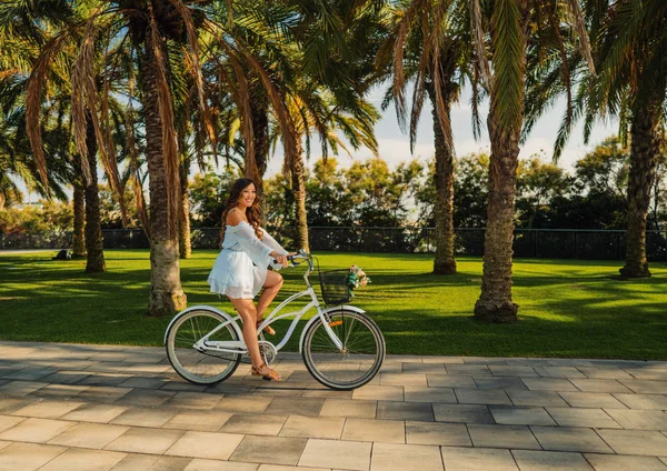 푸른 드레스를 입은 아시아 모델은 녹색 공원에서 흰색 자전거를 타고 — 스톡 사진