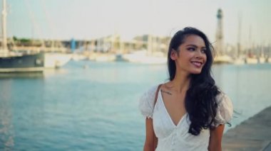 Deniz gezinti boyunca yürüyen beyaz elbiseli güzel kız