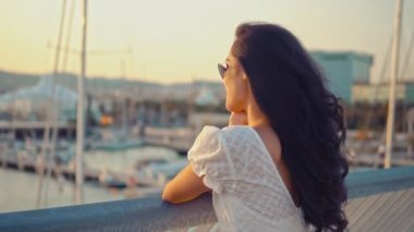 Deniz gezinti boyunca yürüyen beyaz elbiseli güzel kız