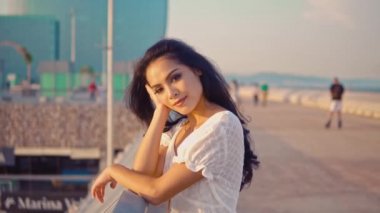 deniz gezinti terasında duran beyaz elbiseli kız