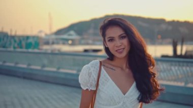 Deniz gezinti boyunca yürüyen beyaz elbiseli güzel kız
