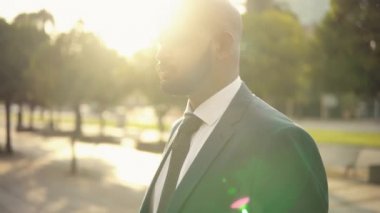 Seyahat çantası veya bavuluyla ayakta mavi takım elbise giyen Hintli işadamı