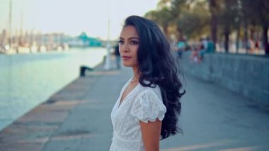 Deniz gezinti boyunca yürüyen beyaz elbiseli güzel kız