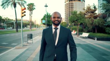 Ofis veya otel yakınında yürürken mavi takım elbise giyen Hintli işadamı