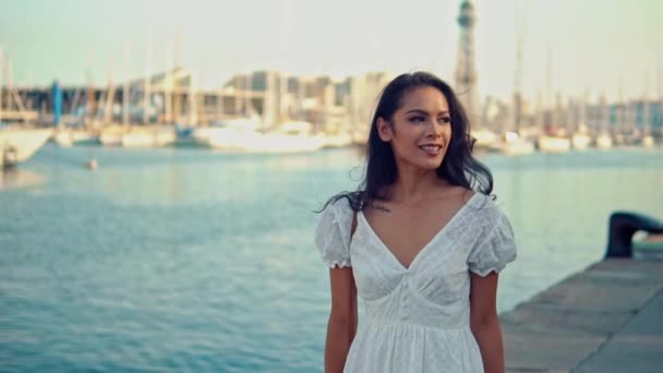 海の遊歩道に沿って歩く白いドレスの美しい女の子 — ストック動画