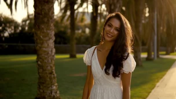 女孩在白色礼服沿着棕榈树露台走 — 图库视频影像