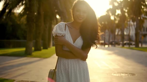 女孩在白色礼服沿着棕榈树露台走 — 图库视频影像