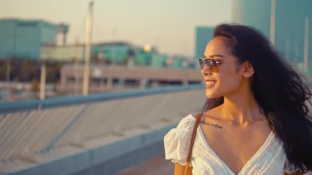 Vacker flicka i den vita klänningen promenader längs strandpromenaden — Stockvideo