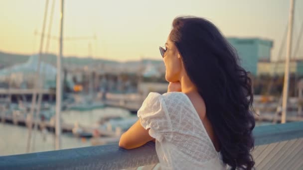 Vacker flicka i den vita klänningen promenader längs strandpromenaden — Stockvideo