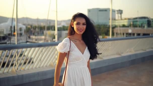 Όμορφο κορίτσι με το λευκό φόρεμα που περπατάει κατά μήκος του θαλάσσιου περιπάτου — Αρχείο Βίντεο