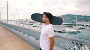 Kaykaycı modern şehir terasında kaykay ile duruyor