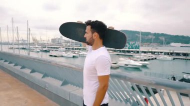 Kaykaycı modern şehir terasında kaykay ile duruyor