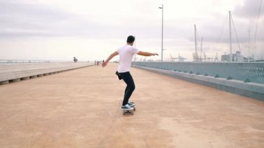 Kaykaycı modern şehir terasında bir kaykay sürmek.