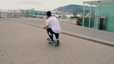 Kaykaycı modern şehir terasında bir kaykay sürmek.
