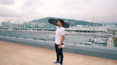 Kaykaycı modern şehir terasında bir kaykay sürmek.