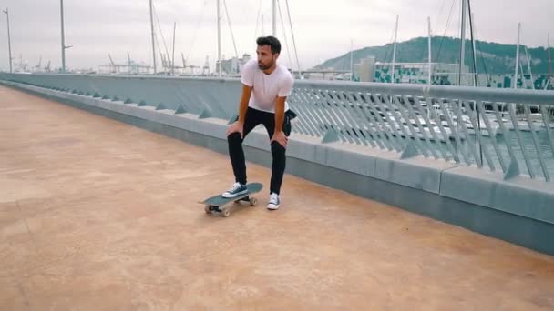 Skateboarder monta un monopatín en la moderna terraza de la ciudad . — Vídeos de Stock