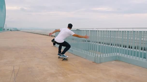 Skateboarder jeździ na deskorolce na nowoczesnym tarasie miejskim. — Wideo stockowe