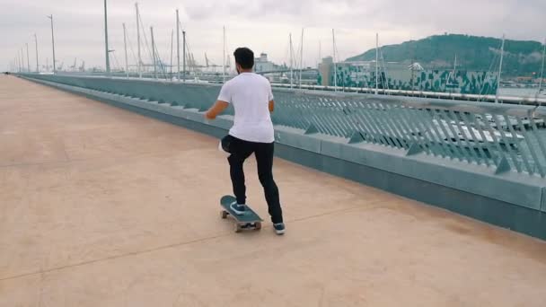 Skateboarder jeździ na deskorolce na nowoczesnym tarasie miejskim. — Wideo stockowe