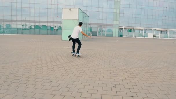 Skateboarder monta un monopatín en la moderna terraza de la ciudad . — Vídeos de Stock