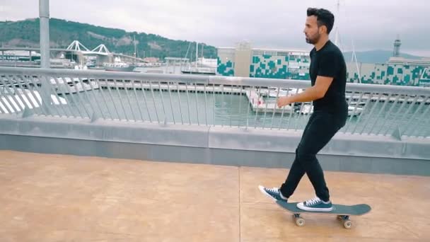 Skateboarder monta un monopatín en la moderna terraza de la ciudad . — Vídeo de stock