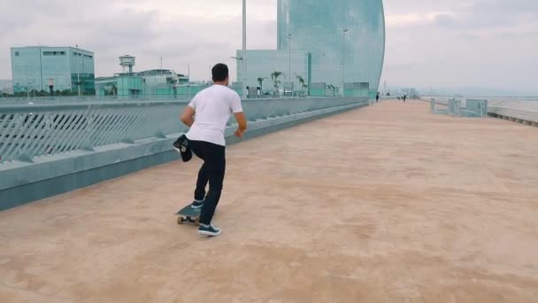 Skateboarder rides a skateboard in the modern city terrace. — Stock Video