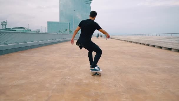 Skateboarder rides a skateboard in the modern city terrace. — Stock Video